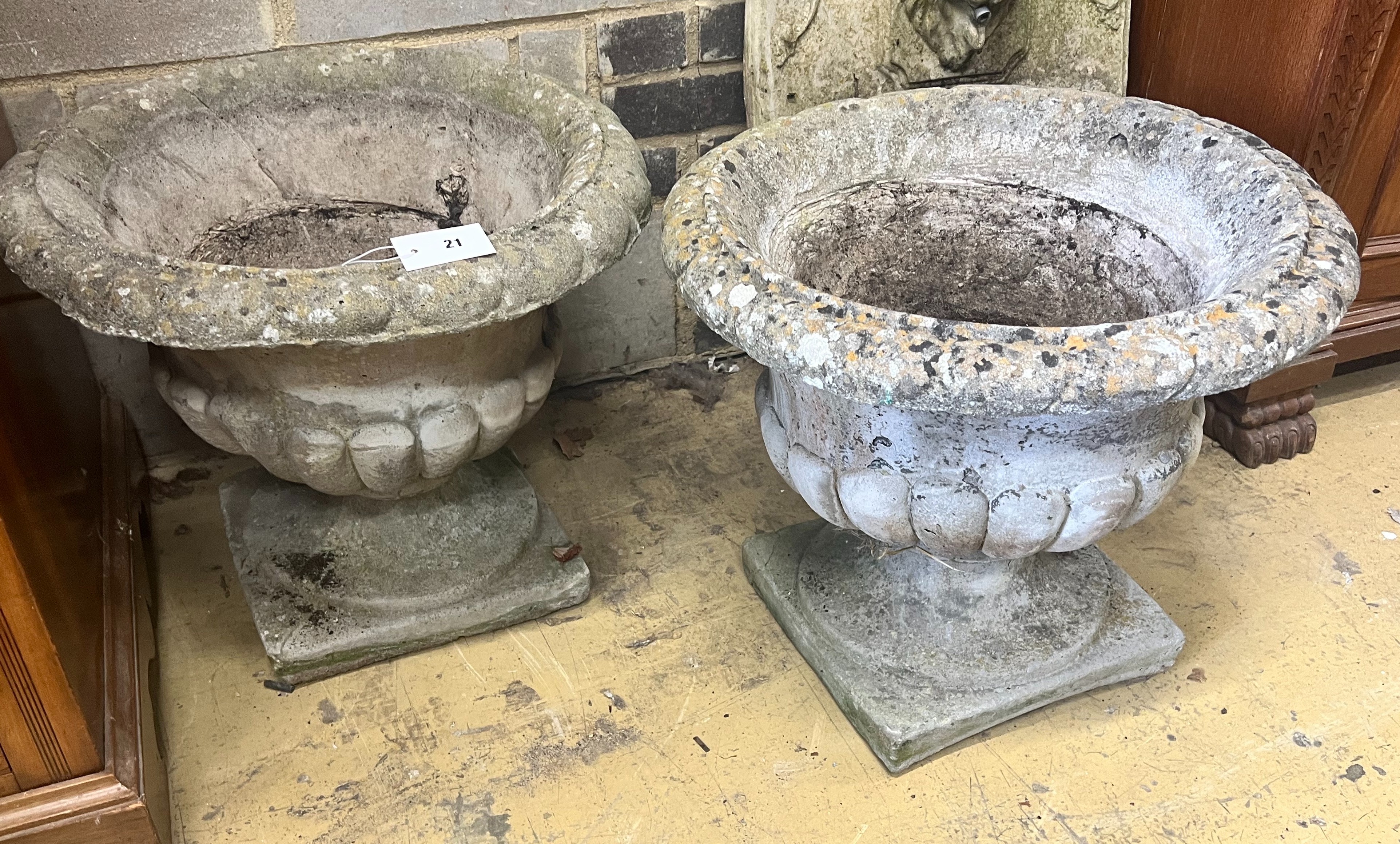 A pair of reconstituted stone circular campana garden urns, diameter 54cm height 48cm